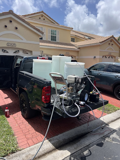Pressure washer equipment on truck parked in residential driveway on sunny day